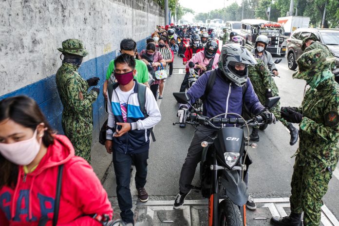 Soldiers man a checkpoint in the northern boundary of the Philippine capital Manila ahead of the implementation of the enhanced community quarantine in a bid to contain the spread of the coronavirus in early 2020. (Photo by Mark Saludes)