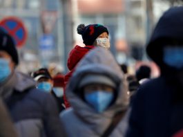 FILE PHOTO: People wearing masks walk in a street in Beijing's CBD during morning rush hour