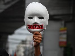 A activist raises a mask during an International Human Rights Day march in Manila on Dec. 10, 2020, to call for justice to alleged human rights abuses committed by state forces. (Photo by Jire Carreon)