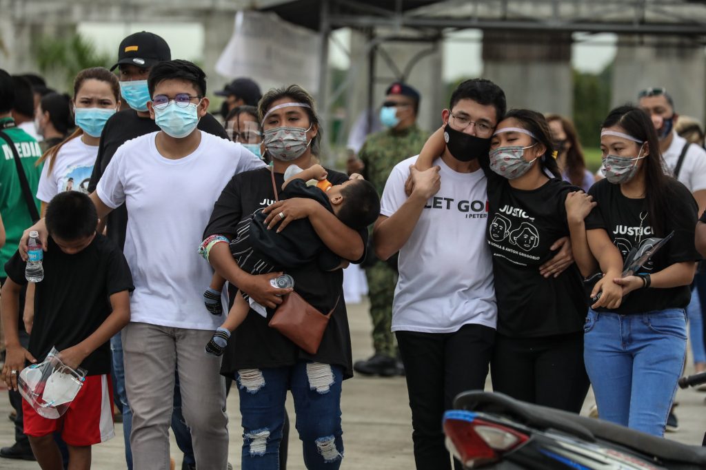 Family members walk behind the hearse carrying the remains of mother and son Sonia and Frank Anthony Gregorio who were laid to rest in the town of Paniqui in the province of Tarlac on Dec. 27. (Photo by Jire Carreon)