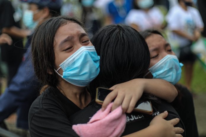 A family member cries in grief at the funeral of mother and son Sonia and Frank Anthony Gregorio, who were killed by a police officer in the province of Tarlac on Dec. 20. (Photo by Jire Carreon)