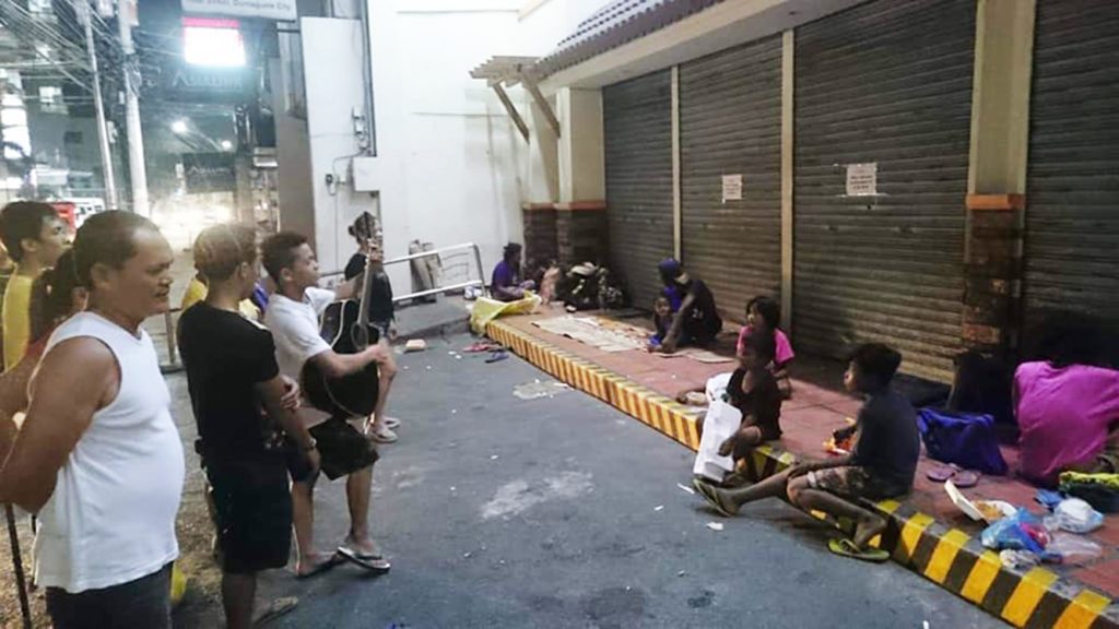 A church choir in the city of Dumaguete serenades street dwellers on Christmas Day. (Photo courtesy of Father Christian Benjamin)