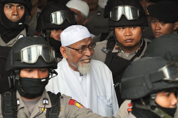 A file image of heavily armed police escorting radical cleric Abu Bakar Bashir (center) at South Jakarta prosecutor’s office on Dec. 13, 2010 as the alleged spiritual leader of Indonesian jihad, or holy war, was transferred from prison. (Photo by Bay Ismoyo/AFP)