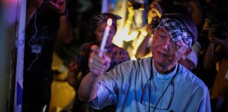 Bishop Broderick Pabillo, apostolic administrator of the Archdiocese of Manila, holds a candle during a demonstration in Manila in 2019. (Photo by Jire Carreon)