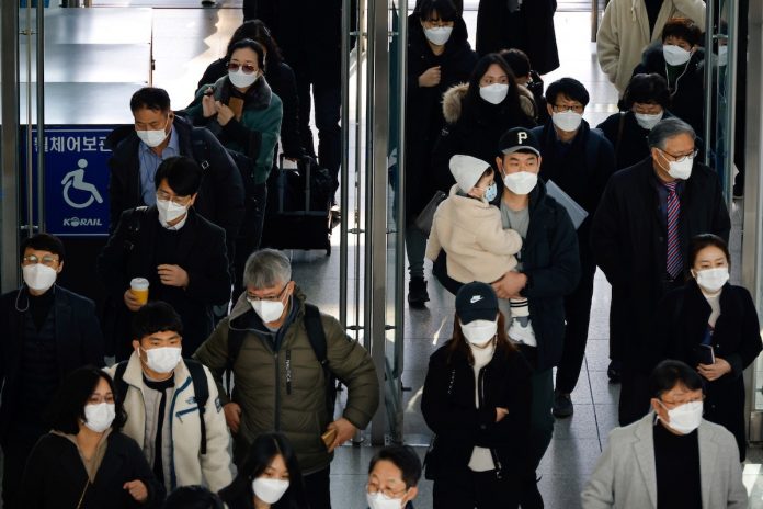 People wearing masks walk at a railway station amid the new coronavirus pandemic in Seoul, South Korea, Nov. 30, 2020. (Photo by Kim Hong-ji/Reuters)