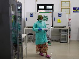 An analyst of Global Halal Center walks inside a laboratory, where the Sinovac's vaccine for COVID-19 was analyzed for Halal certification, in Bogor, Indonesia, Jan. 6. (Photo by Willy Kurniawan/Reuters)