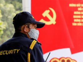 A security officer stands guard near a poster for the upcoming 13th National Congress of the ruling Communist Party of Vietnam, on a street in Hanoi, Vietnam Jan. 12. (Photos by Kham/Reuters)