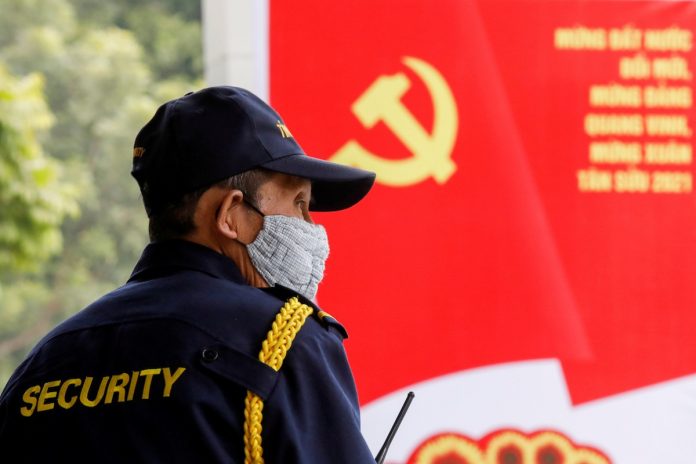A security officer stands guard near a poster for the upcoming 13th National Congress of the ruling Communist Party of Vietnam, on a street in Hanoi, Vietnam Jan. 12. (Photos by Kham/Reuters)