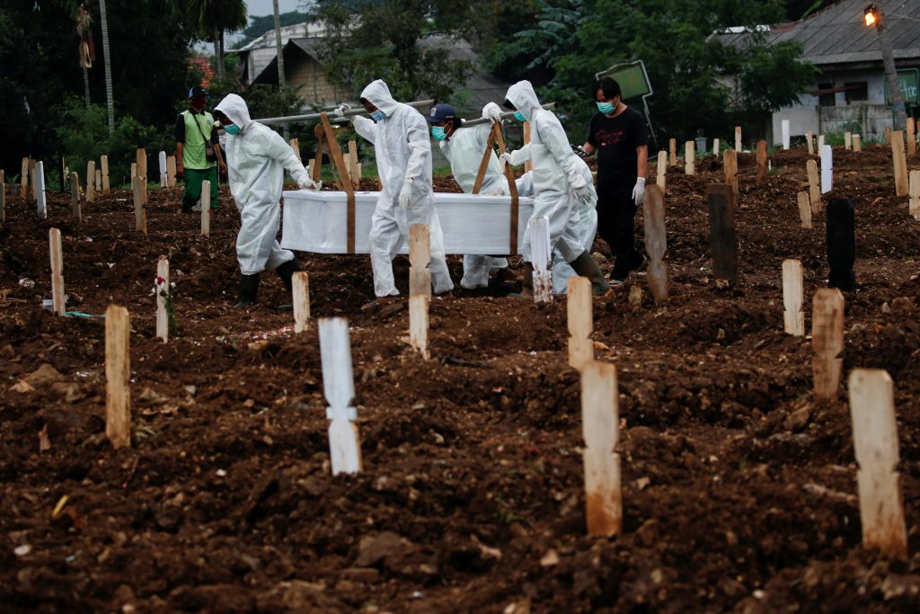 Municipality workers carry the coffin of a coronavirus victim at a burial area provided by the government for COVID-19 victims at the Srengseng Sawah cemetery complex, in Jakarta, Indonesia, Jan. 25. (Photo by Willy Kurniawan/Reuters)