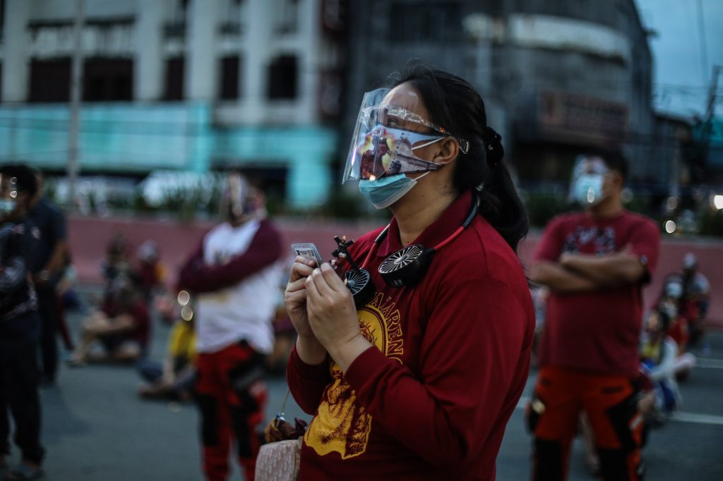 A devotee of the Black Nazarene prays outside the church in Manila’s Quiapo district during its annual “feast” on Jan. 9, 2021. (Photo by Jire Carreon)