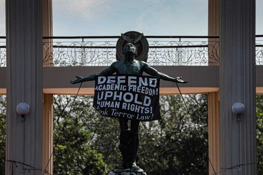 A sign that reads “Defend Academic Freedom” hangs on the “Oblation” statue in the University of the Philippines on January 28. The Oblation is a concrete statue that serves as the iconic symbol of the University of the Philippines. (Photo by Jire Carreon)