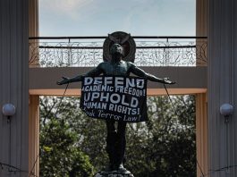 A sign that reads “Defend Academic Freedom” hangs on the “Oblation” statue in the University of the Philippines on January 28. The Oblation is a concrete statue that serves as the iconic symbol of the University of the Philippines. (Photo by Jire Carreon)