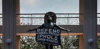 A sign that reads “Defend Academic Freedom” hangs on the “Oblation” statue in the University of the Philippines on January 28. The Oblation is a concrete statue that serves as the iconic symbol of the University of the Philippines. (Photo by Jire Carreon)