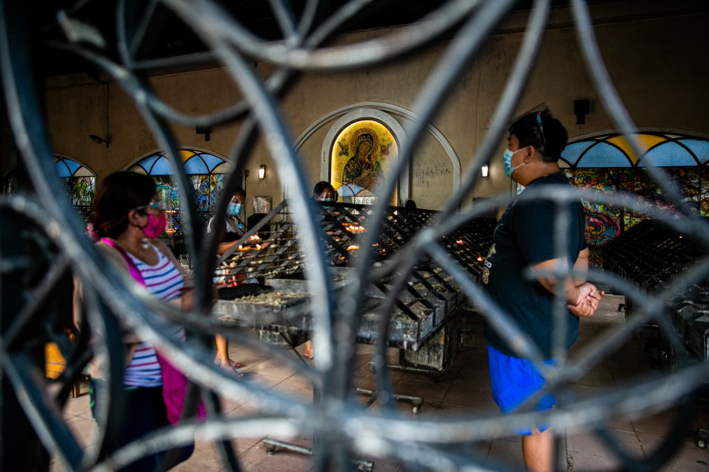 Devotees of the Our Mother of Perpetual Help and the Black Nazarene offer candles and prayers during the pilgrim visit of the image of the suffering Christ in Baclaran church on January 7. (Photo by Mark Saludes)