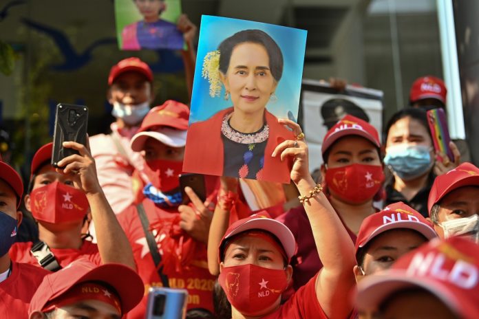 Myanmar migrants hold up portraits of Aung San Suu Kyi as they take part in a demonstration outside the Myanmar embassy in Bangkok on Feb. 1, after Myanmar's military detained the country's de facto leader Suu Kyi and the country's president in a coup. (Photo by Lillian Suwanrumpha/AFP)