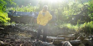 A man stands on the ground where he burned wood and excavated soil to make charcoal | LiCAS.news